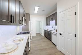 A modern kitchen with white cabinets and a white countertop.