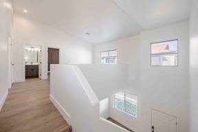 A white interior with wooden floors and a window.
