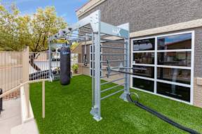 A home gym setup with a pull up bar and a punching bag.