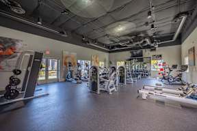 A gym with a variety of equipment including treadmills, weights, and exercise machines.