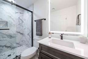 A white sink in a marble bathroom.