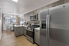 A modern kitchen with a refrigerator, oven, and microwave.