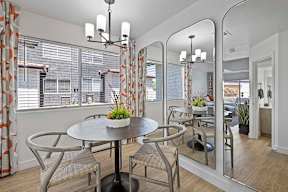 A dining room with a round table and chairs.