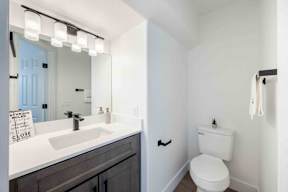 A white toilet sits next to a sink in a bathroom.
