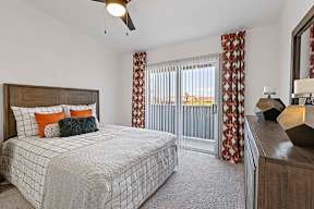 A bedroom with a large bed and a ceiling fan.