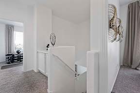 A white staircase with a metal railing in a room.