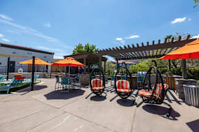 A patio with orange umbrellas and chairs.