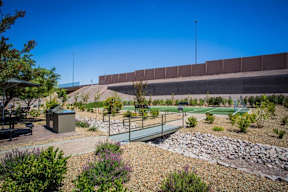 A park with a playground and a wall in the background.