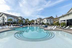 A large swimming pool in front of a resort.