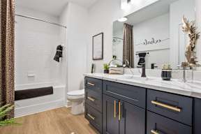 A bathroom with a white toilet, a white sink, and a white countertop.
