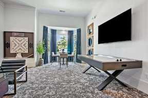 A room with a pool table and a TV on the wall.