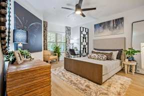 A bedroom with a large bed and a wooden dresser.