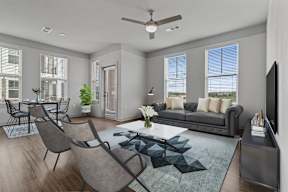 A modern living room with a grey sofa, a coffee table, and a television.