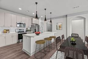 A modern kitchen with a dining table and chairs.
