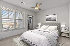 A bedroom with a large bed and a ceiling fan.