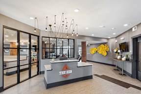The lobby of a building with a reception desk and a clock on the wall.