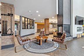 A modern living room with a fireplace and leather chairs.