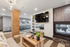 A modern living room with a fireplace and a flat screen TV.