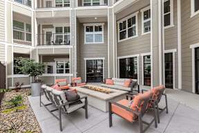 A patio with a table and chairs is in front of a building.