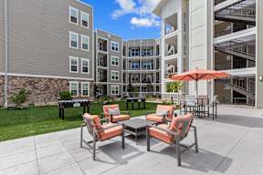 A patio with a table and chairs is in front of a building.