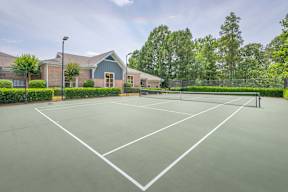 A tennis court with a building in the background.