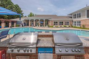Two grills are located outside of a house.