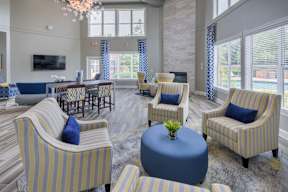 A living room with striped chairs and a round ottoman.