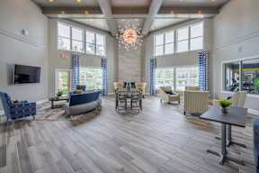 A spacious living room with a large window and a TV mounted on the wall.