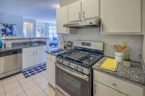 A modern kitchen with a stove top oven and a counter top.