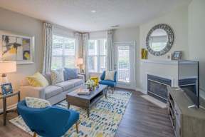 A living room with a blue chair and a grey couch.