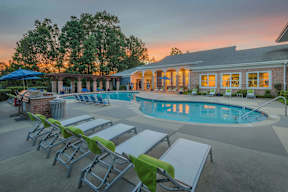 A poolside area with sun loungers and a building in the background.