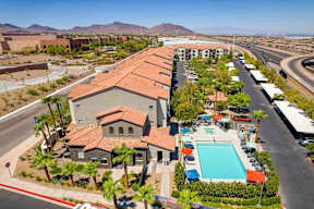 an aerial view of a building with a pool and parking lot