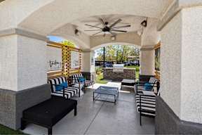 a covered patio with tables and chairs and a ceiling fan