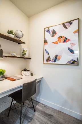 an office with a desk and a painting on the wall