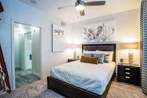 a bedroom with a large bed and a ceiling fan