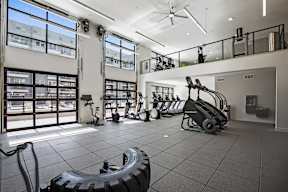 A gym with treadmills, elliptical machines, and weights.