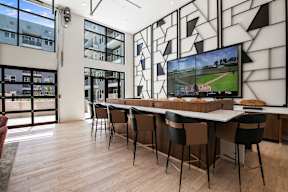 A modern room with a long table and chairs, a television, and a large window.