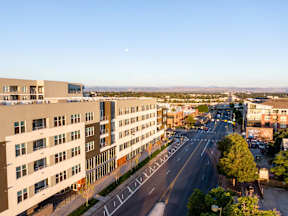 A large building is on the left and a road is in the middle of the image.