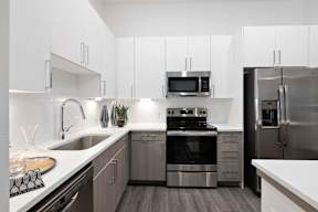 A modern kitchen with stainless steel appliances and white cabinets.