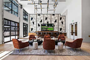 A modern living room with a large screen tv and comfortable seating.