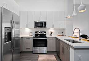 A modern kitchen with a stainless steel refrigerator and a stove top oven.