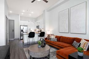 A modern living room with a brown sofa and a grey coffee table.