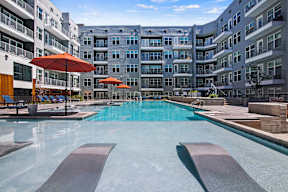 A large swimming pool with a metal diving board in the middle of it.