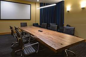 A conference room with a large table and chairs.