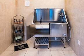 A cleaning station with a sink and a basket of cleaning supplies.