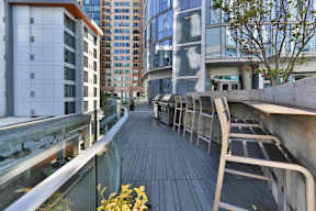 A long wooden walkway with metal railings and benches on either side.