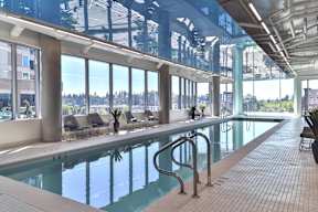 A large indoor swimming pool with a glass ceiling and a view of the outdoors.