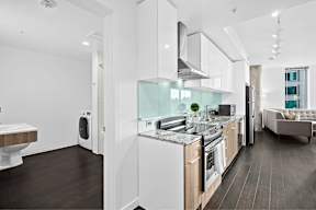 A modern kitchen with white appliances and wooden cabinets.