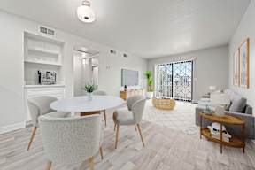 A white dining table with chairs and a sofa in a room.