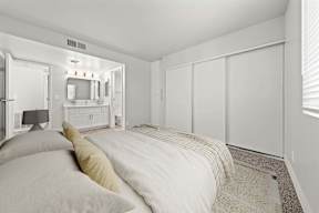 Bedroom with bed, dresser, and a mirror at Station 21 apartments for rent in Mesa.